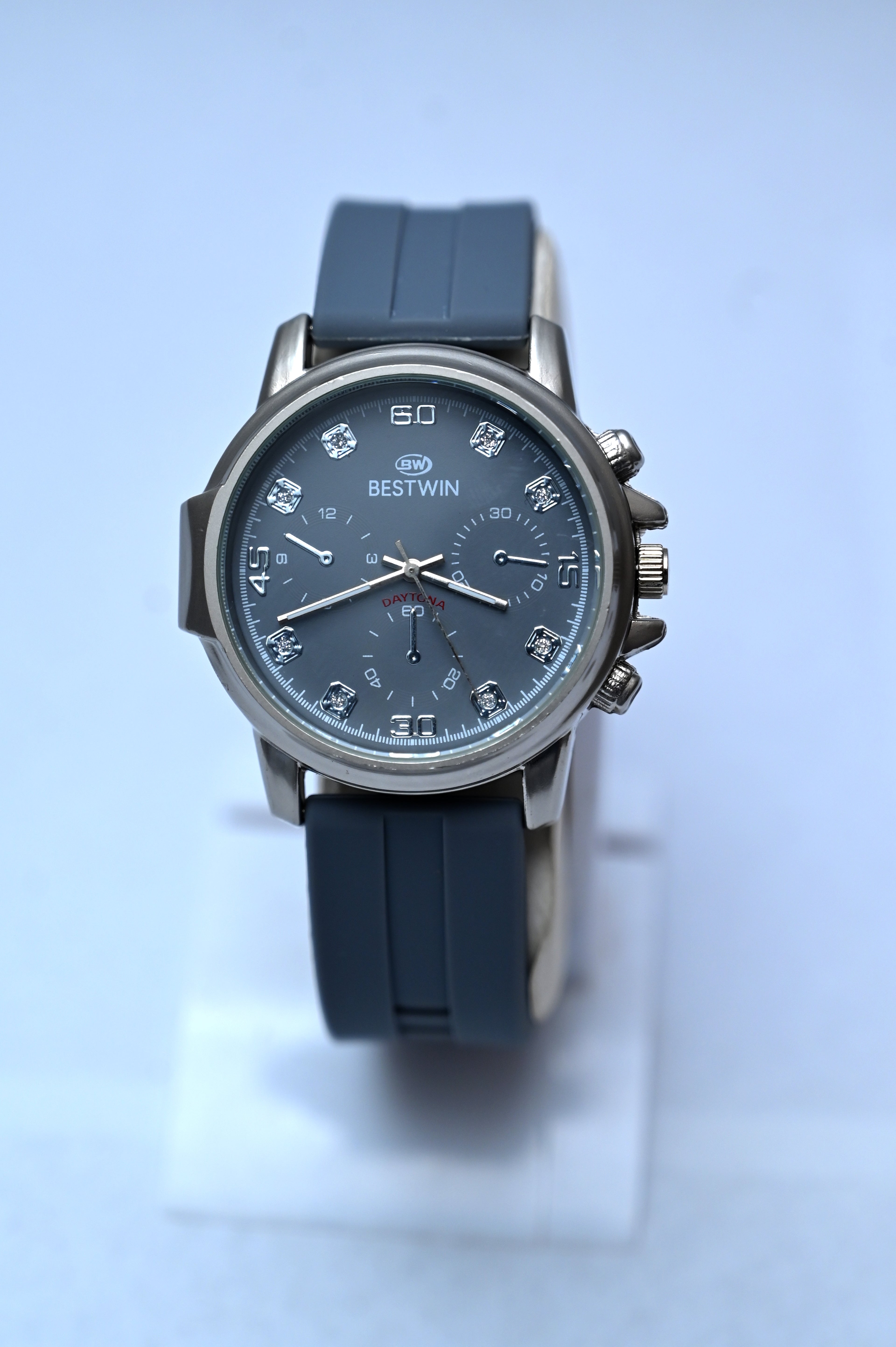 Blue wristwatch with a detailed face on a light blue background