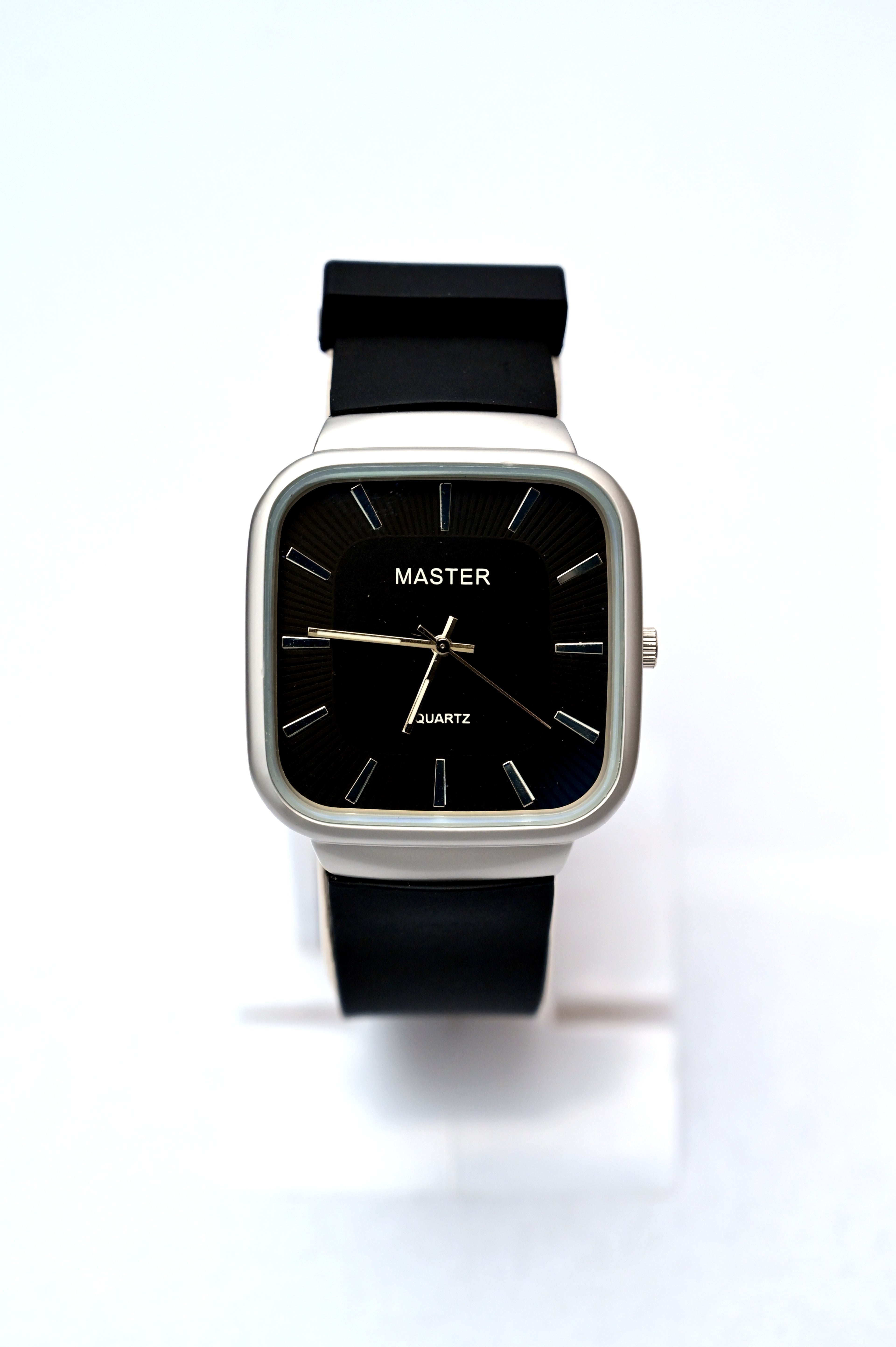 Black wristwatch with a white case on a white background