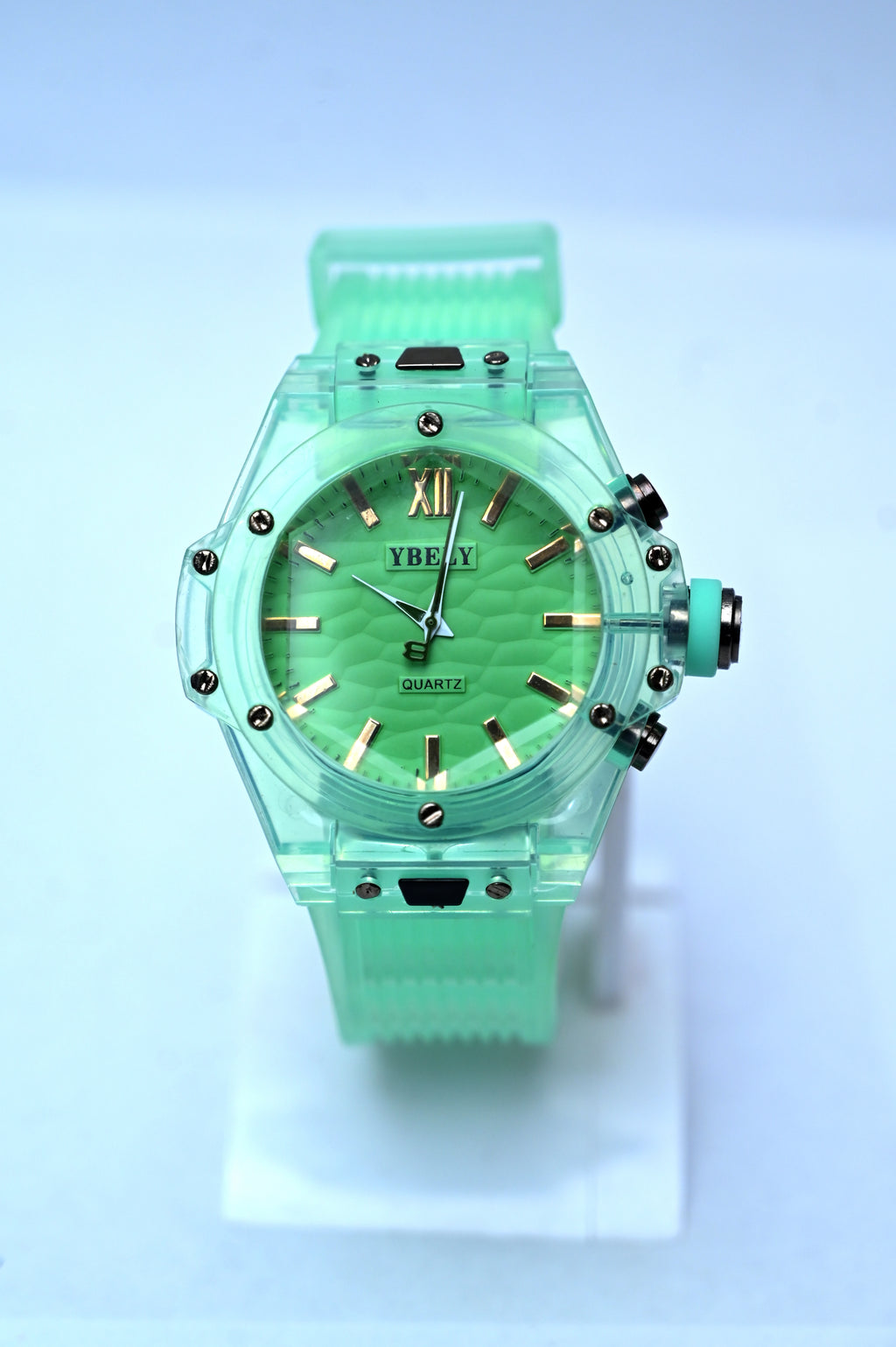 Green watch with a transparent band on a light blue background