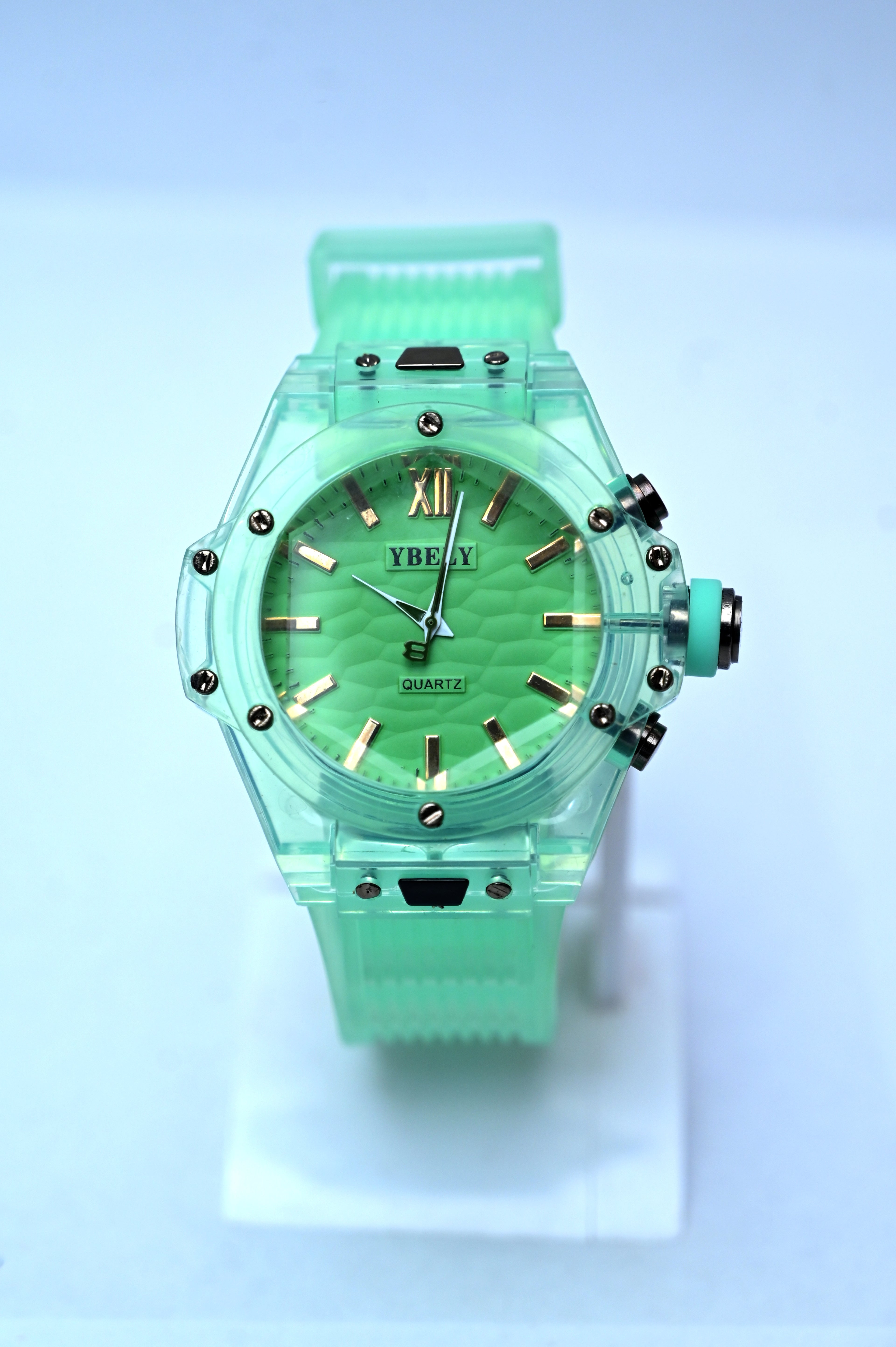 Green watch with a transparent band on a light blue background